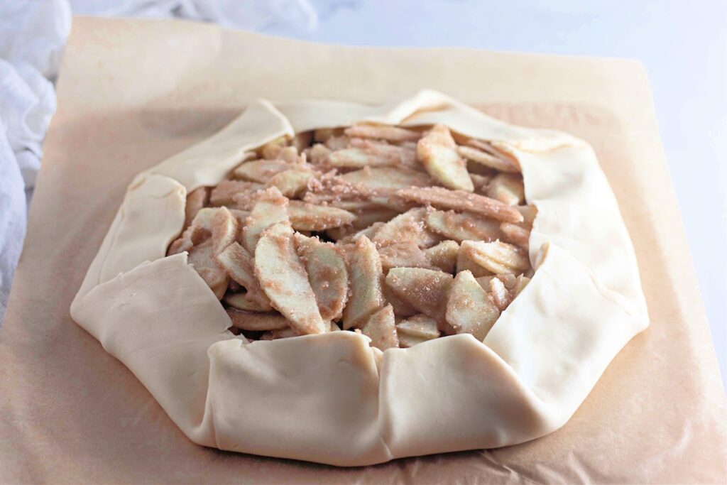 Pie crust with slices of apples in the center