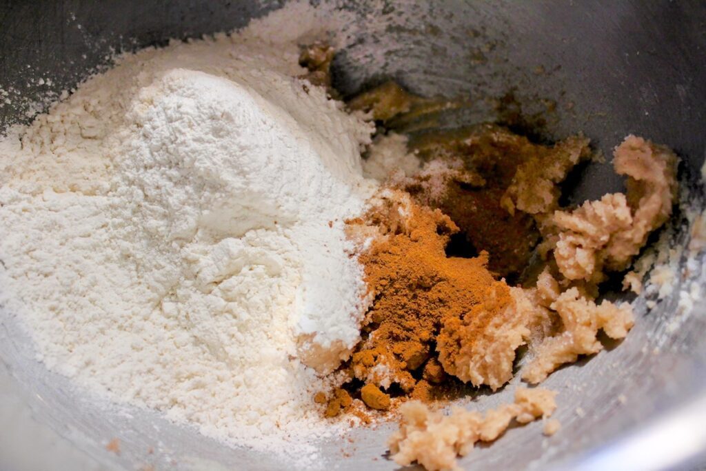 Adding flour, sugar, and pumpkin spice for pumpkin streusel cookies recipe