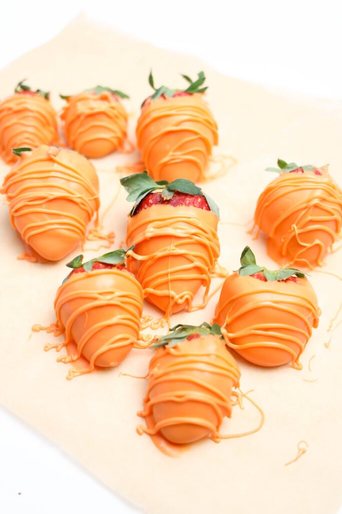 Strawberry covered in orange color melted candy