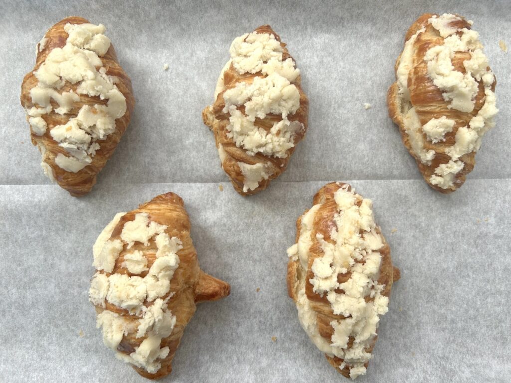 Croissants stuffed with dough lined in a baking sheet