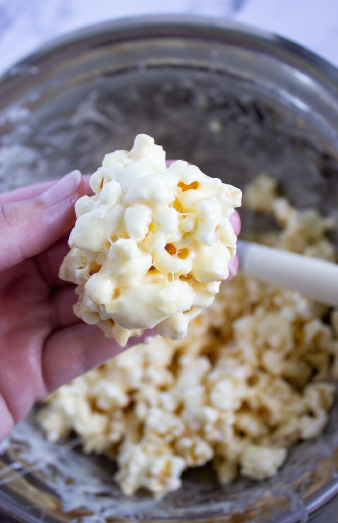 Shaping marshmallow coated popcorn into a golf ball size