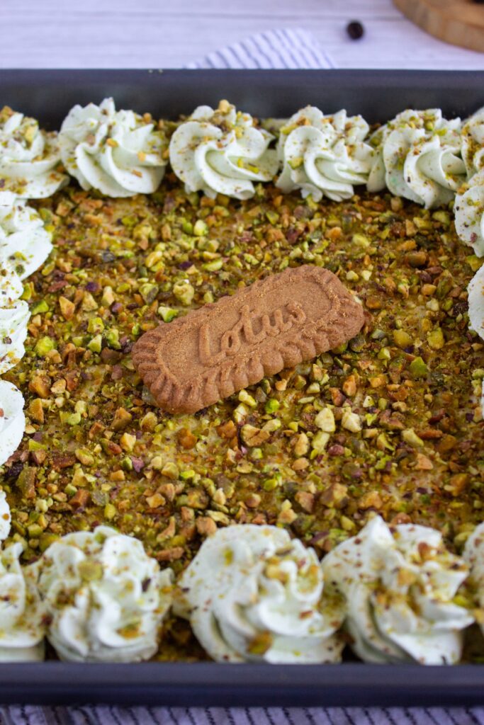 Pistachio biscoff tiramisu topped with pistachio and whipped cream