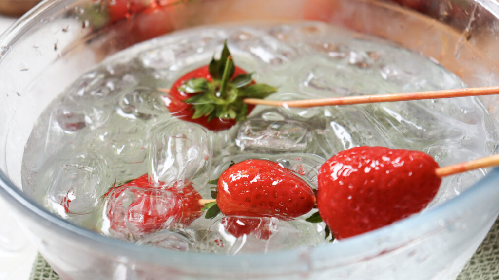 Strawberries dipped in bowl of water with ice