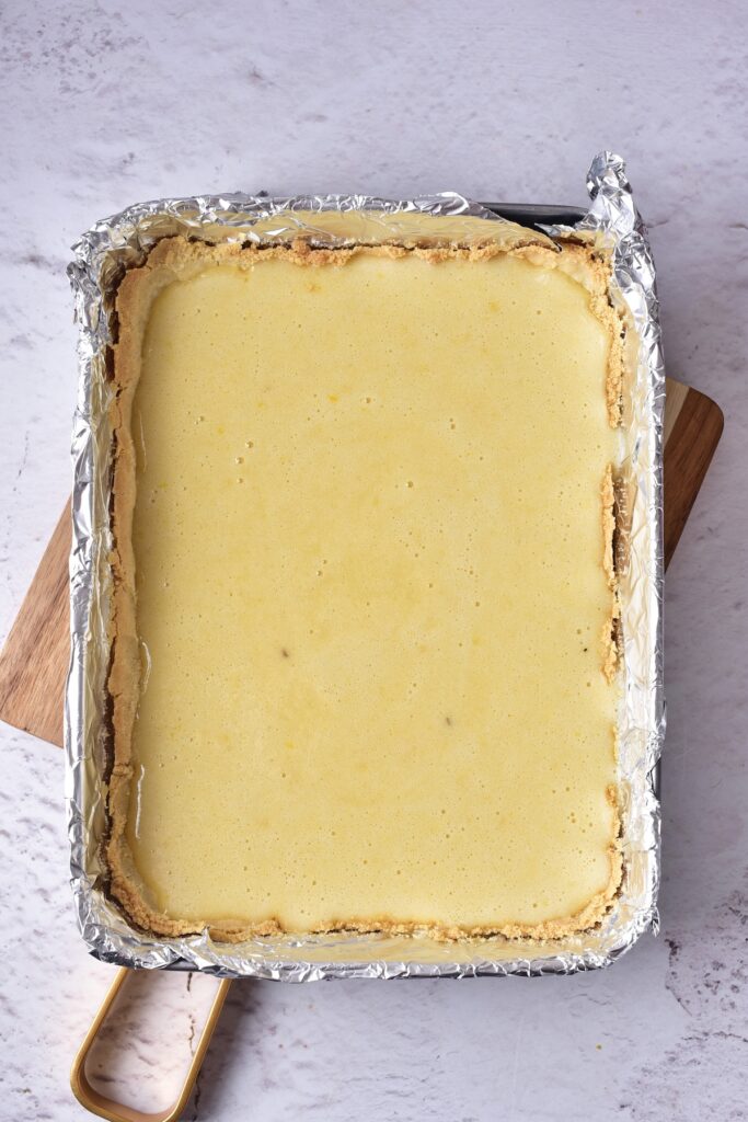 Lemon bar mixture in a baking pan covered with foil