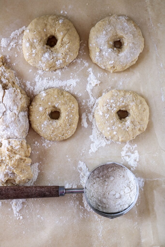 Dough cut with holes in their centers to make doughnuts