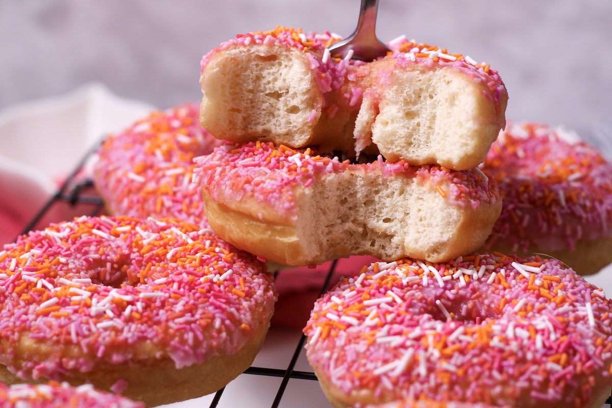 Stack of pink orange home made donuts with sprinkles