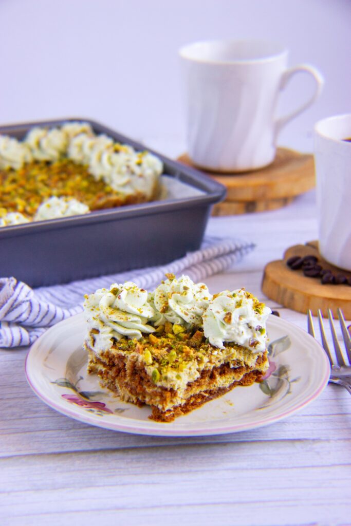 A slice of pistachio biscoff tiramisu in a plate