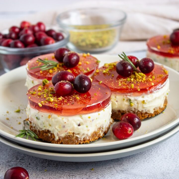 Plate full of pistachio cranberry no-bake mini cheesecakes