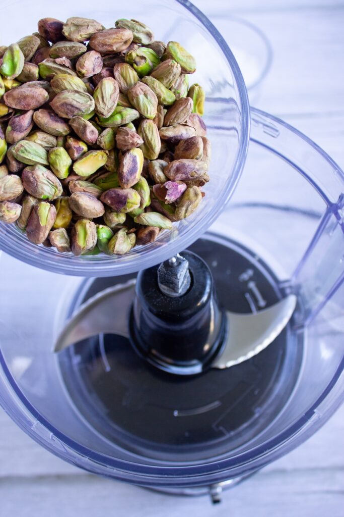 Pouring pistachios inside a food processor