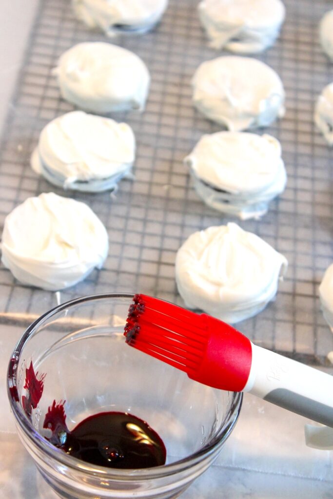 Red coloring in a bowl and a baking brush