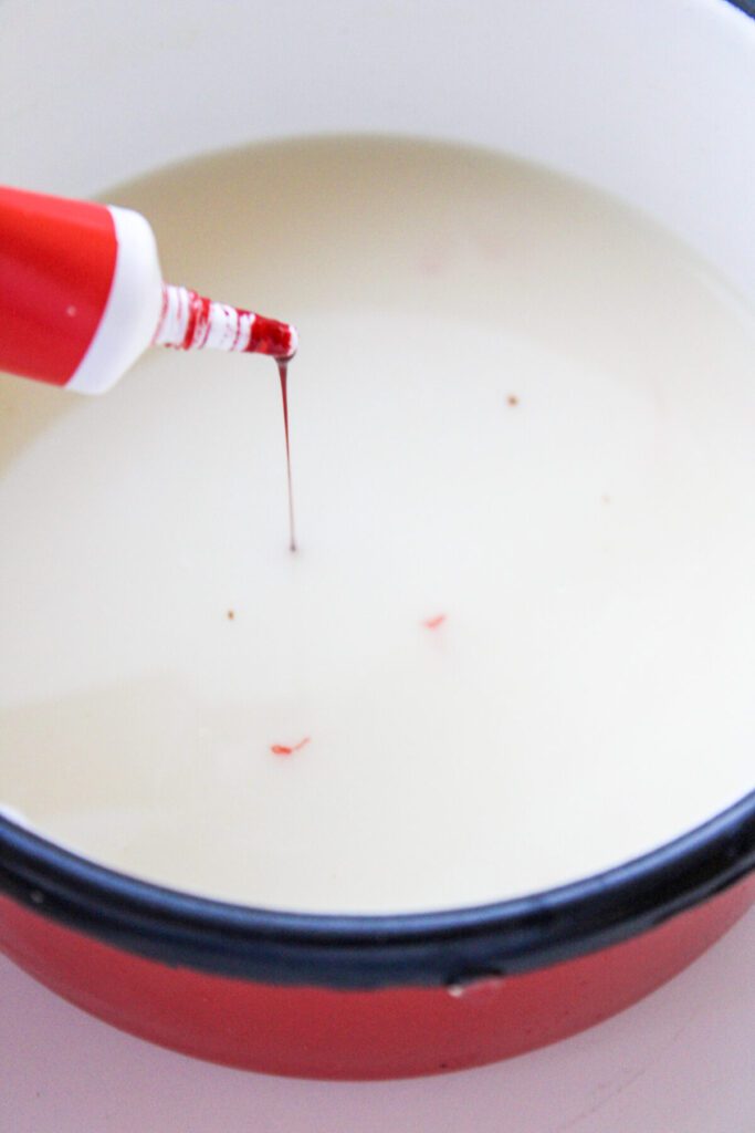 Adding red food color to milk and chocolate mixture