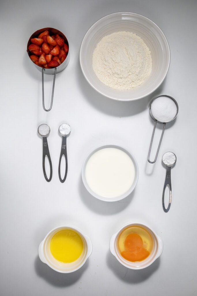 Ingredients for a strawberry pancake - flour, milk, strawberries, butter, sugar, baking soda and salt
