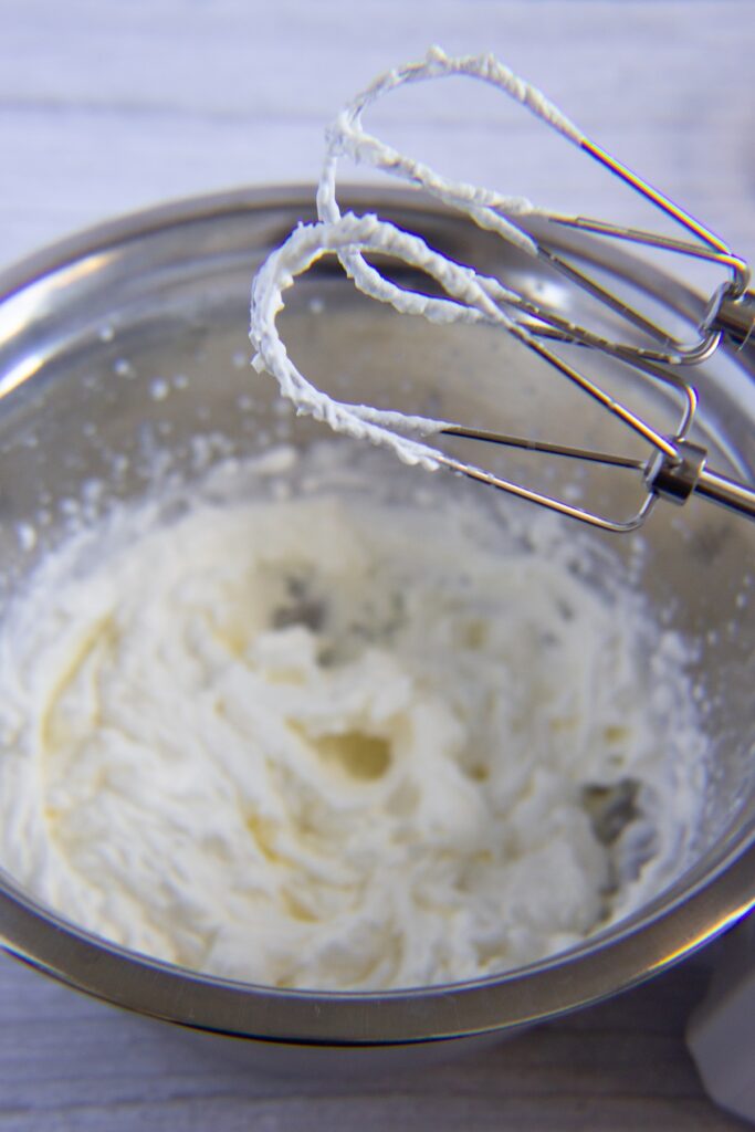 Whipping cream in a bowl using a whisk