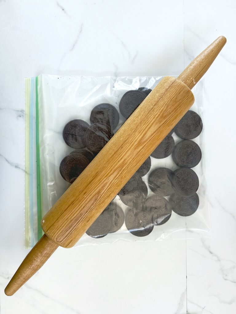 oreos inside a ziplock with a rolling pin on top