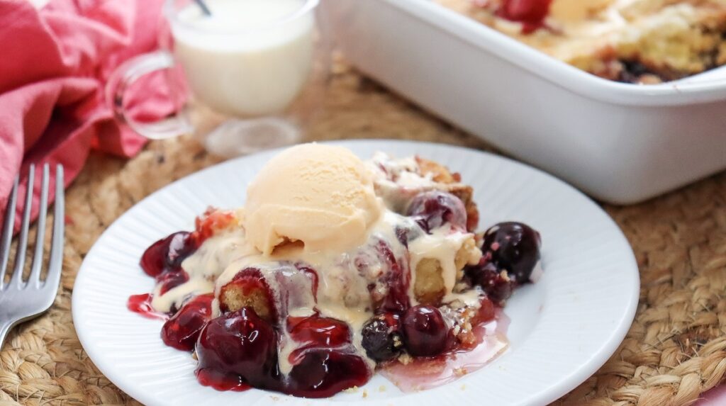cherry dump cake with a scoop of vanilla topping