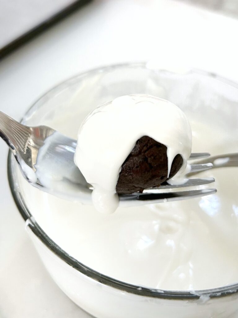dipping oreo balls into the melted chocolate