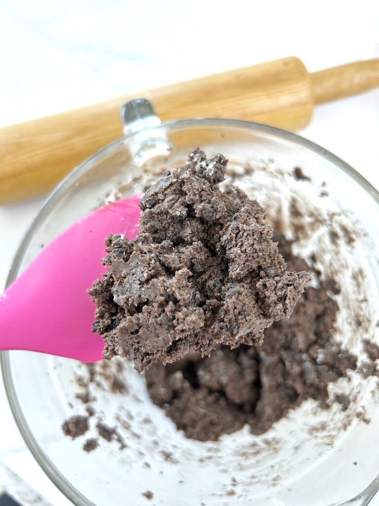 mixed cream cheese and pulverized oreos in a bowl