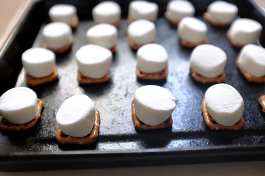 topping pretzels with marshmallows