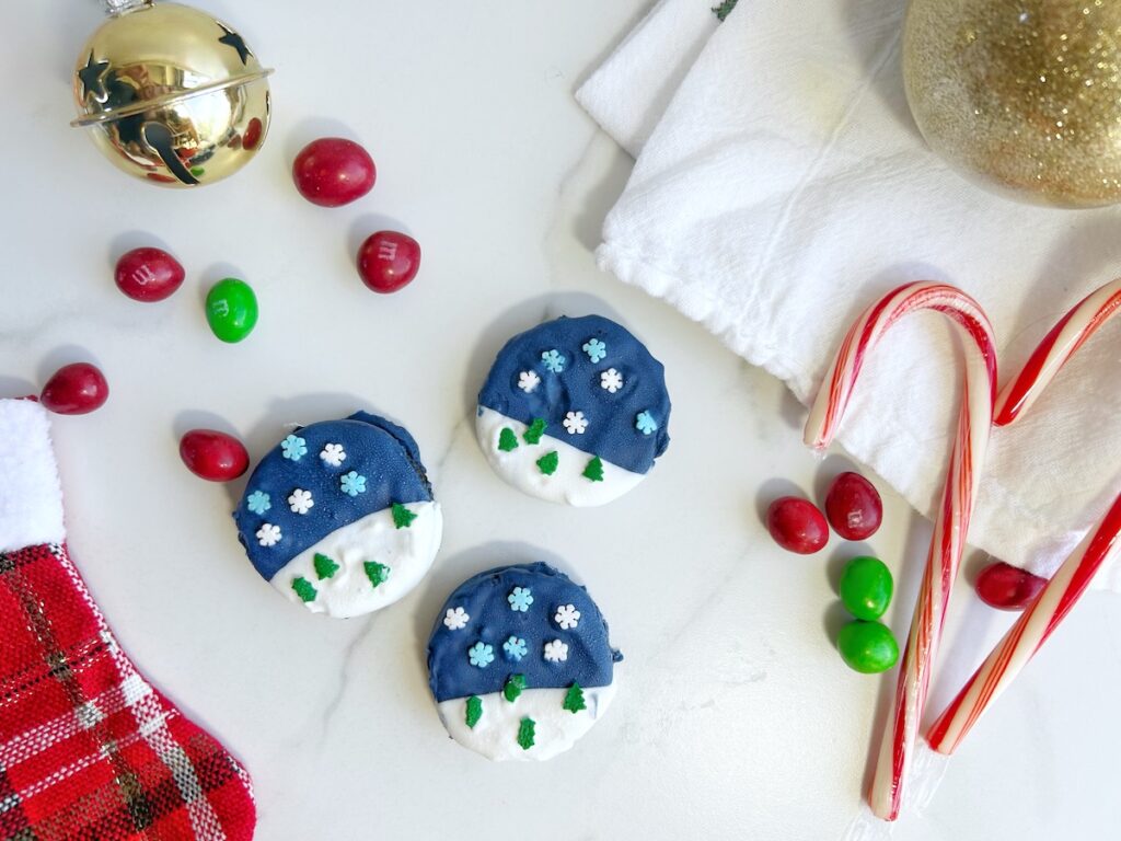 snowglobe dipped oreos with white and blue coating and sprinkles
