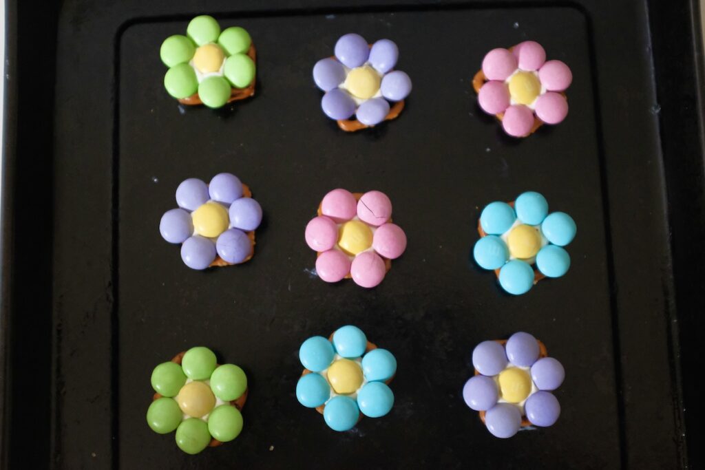 adding m&ms to the pretzels
