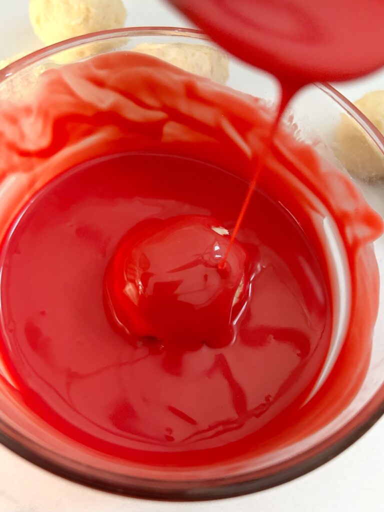 red melted chocolate and one oreo ball coated with it