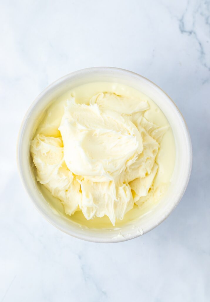 vanilla frosting in a bowl of melted white chocolate
