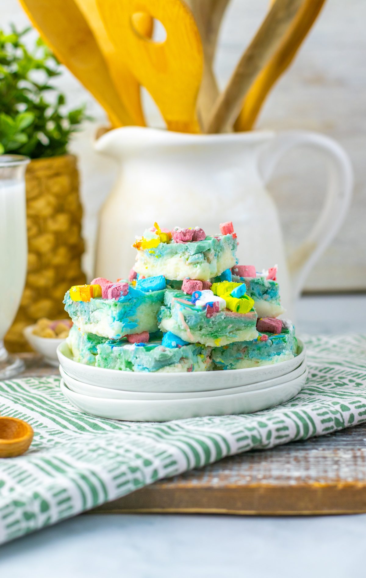 a plate of lucky charm fudge with kitchen utensils in the background