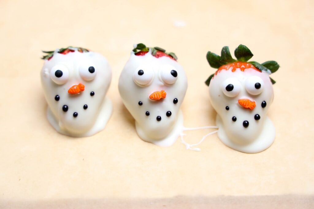 strawberries covered in white chocolate to look like snowmen