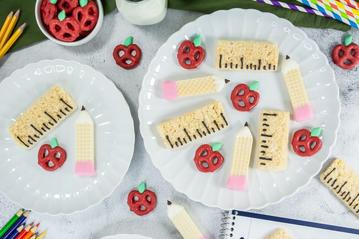 a plate with apple pretzels, ruler rice krispie treats and pencil shaped cookies