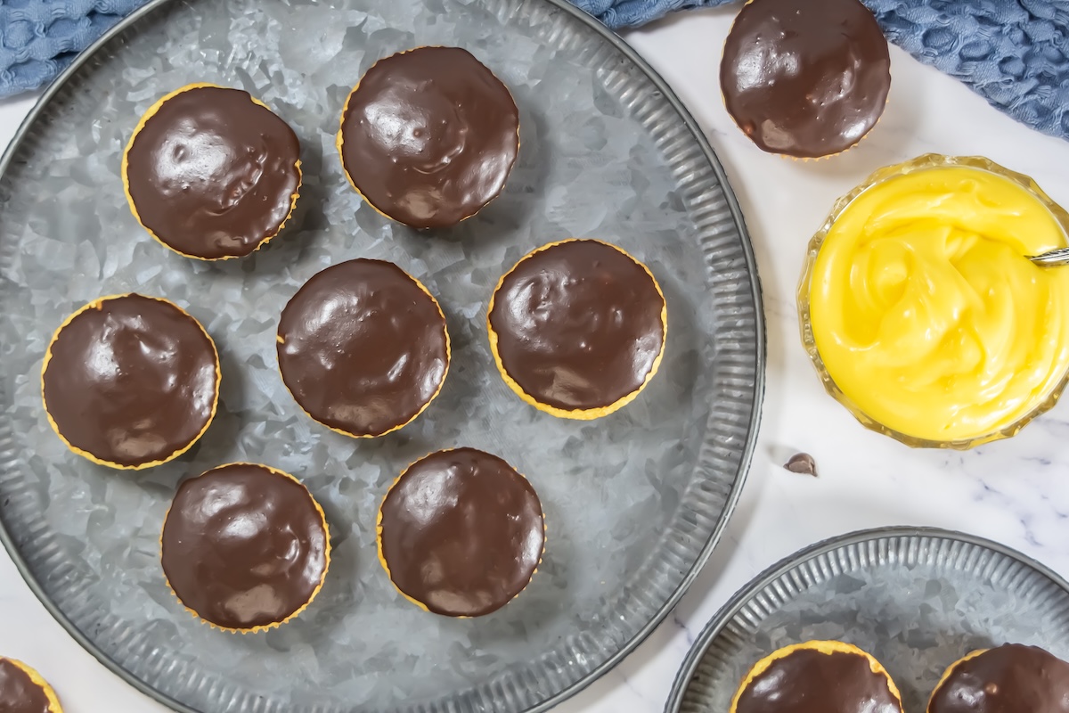 Topdown view of finished Boston Cream Pie cupcakes, showing the shiny chocolate topping and yellow cupcake base