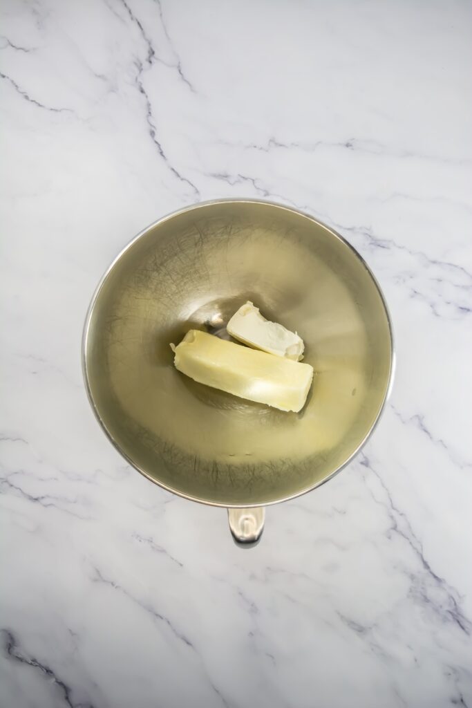 Large mixing bowl with softened butter and cream cheese ready to be creamed for the frosting or filling