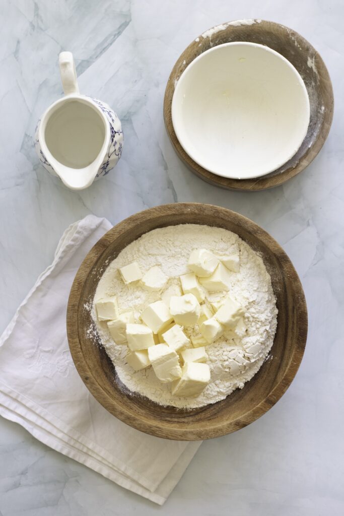 a bowl of flour and butter cubes as a first step to making pie crust