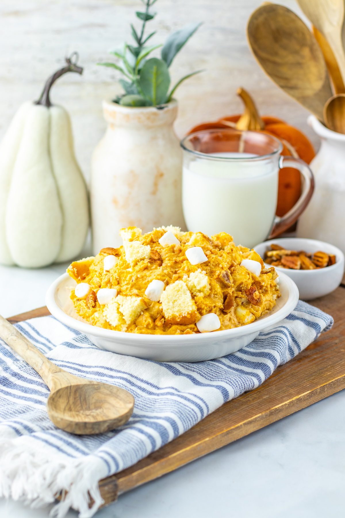 a bowl of pumpkin fluff salad with fall decorations in the background