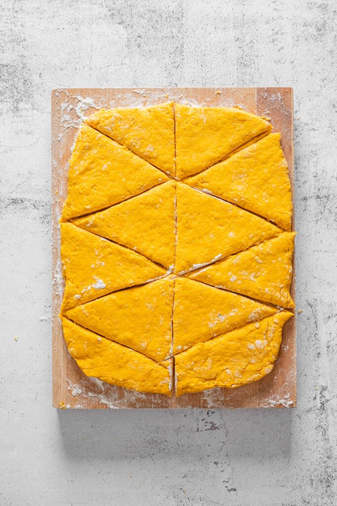 pumpkin scone dough rolled out and cut into wedges