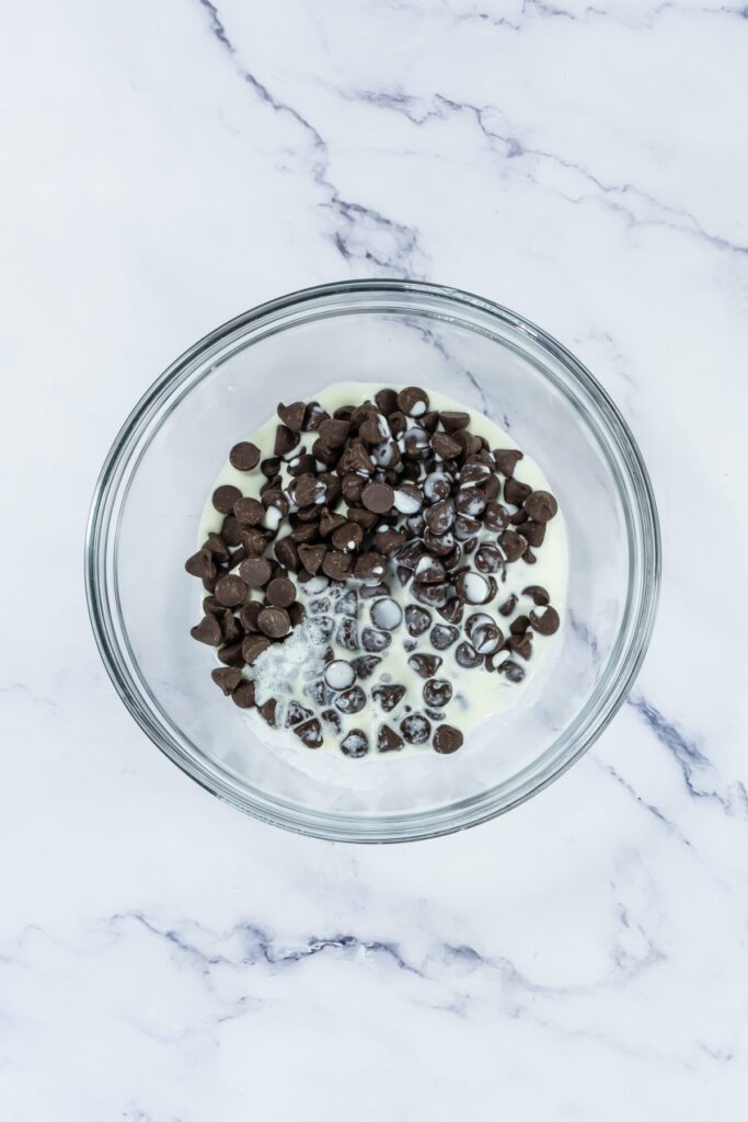 chocolate chips in a bowl with heavy cream for melting