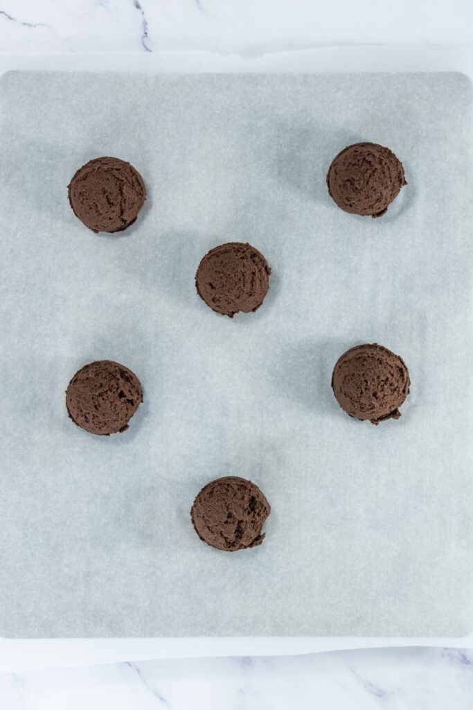 chocolate cookie dough balls on a baking parchment 