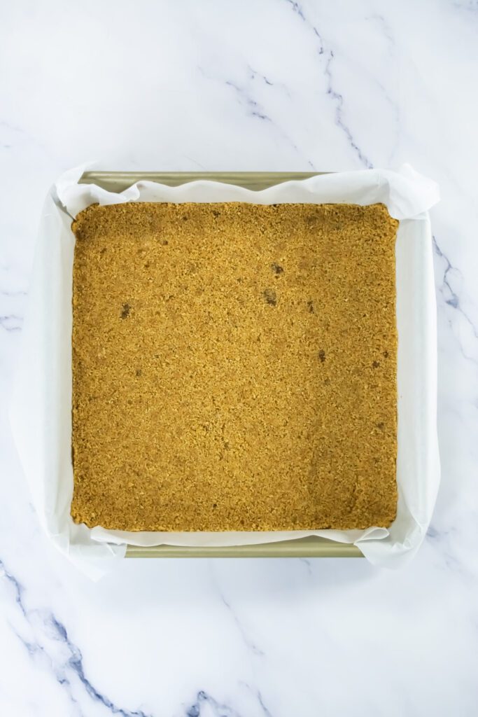 crust in a pan for pumpkin cheesecake bars