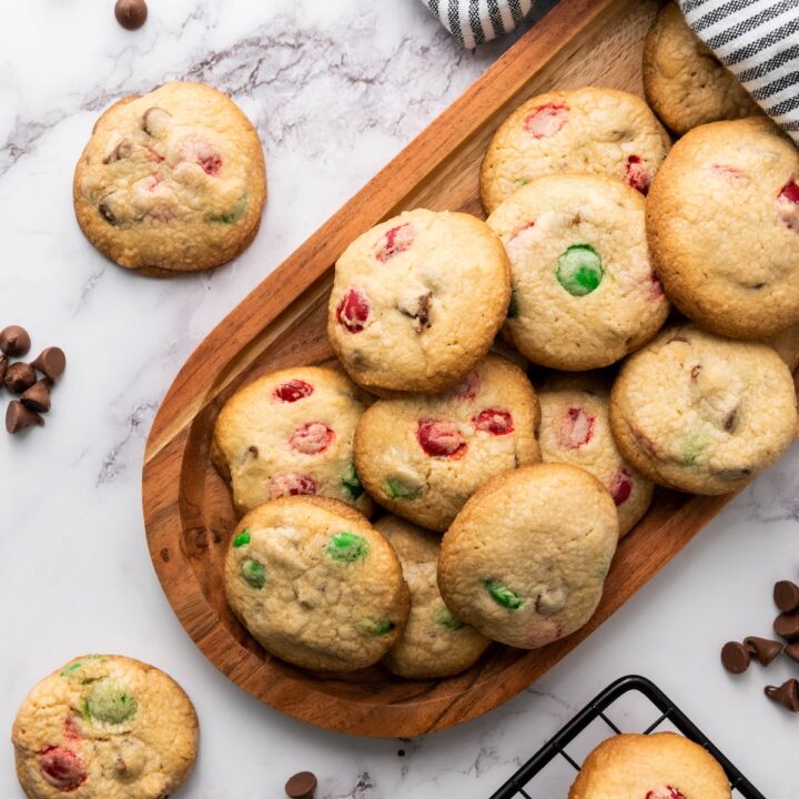 christmas colored m&m cookies on a wooden tray
