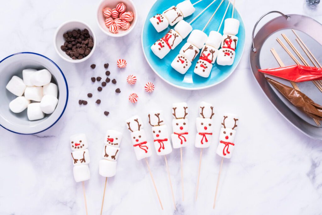 marshmallows kebabs with frosting to look like reindeers and snowmen