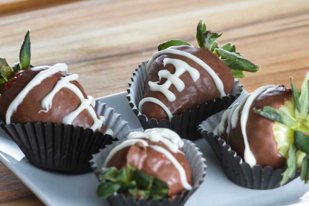 chocolate covered strawberries with white frosting on them to make them look like little footballs